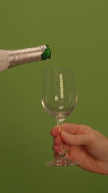 Şampanyayla doldurulmak için güzelce hazırlanmış kadehi zarifçe tutan bir el.