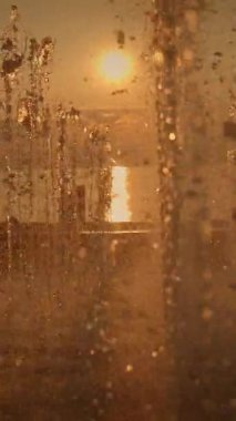 Nefes kesici ve çarpıcı bir gün batımı görüntüsü çeşmeden dökülen su damlacıkları tarafından biraz gizleniyor.