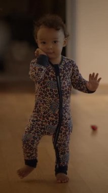 Parlak ve renkli pijama giymiş çekici bir çocuk evde neşeli ve kaygısız bir anın tadını çıkarıyor.