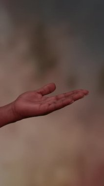 Düşünceli bir jest yaparak, canlı ve renkli bir arkaplana karşı derin duygular ifade eden bir elin yakınlaşması.