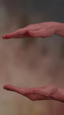 İki el yatay olarak konumlandırılır, bu da dengeyi, sunumu ya da boşluğu temsil eder.