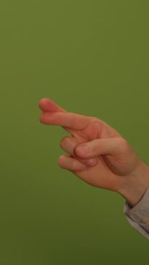 Bir el sıklıkla iyi şansa ya da umuda bağlı bir jest yapar. Parlak yeşil arka planda göze çarpar.