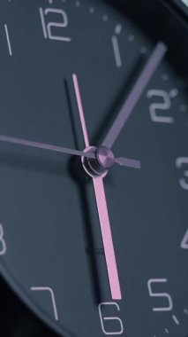 Şık tasarımı ve güzel pembe aksanına odaklanmış çok şık bir siyah saatin detaylı bir görüntüsünü alın.