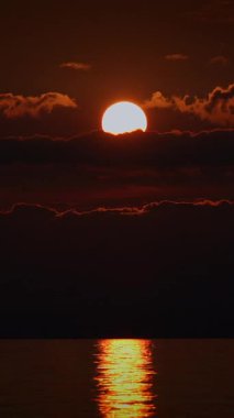 Nefes kesici bir günbatımı, huzurlu bir su kütlesinin huzurlu yüzeyini aydınlatan ılık renkler yayar.