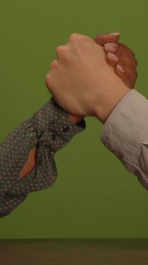 İki el bilek güreşi maçı yapıyor. Hem arkadaşlığı hem de rekabet ruhunu temsil ediyor.