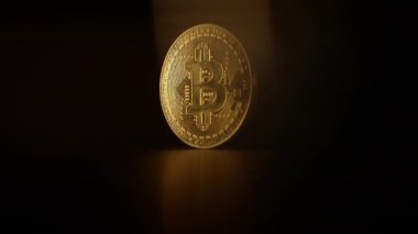 Karanlık bir arka planda parlayan Bitcoin 'in yakın plan görüntüsü kripto para yatırımını temsil ediyor..