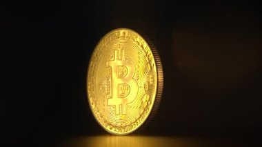 Parlak bir altın Bitcoin, kripto para biriminin muazzam değerini temsil eden karanlık bir zemin üzerine parlak bir ışık saçar.