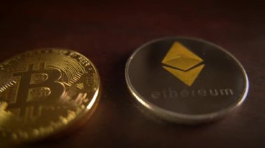 Popüler kripto para birimlerini vurgulayan Bitcoin 'in yanına yerleştirilmiş bir Ethereum metal madeni paranın ayrıntılı yakın plan görüntüsü