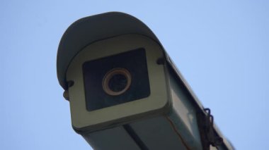 Dalgalı mavi gökyüzüne karşı güvenlik ve etkin bölge gözetimi sağlayan bir güvenlik kamerası.