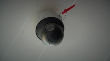 Modern bir tavana monte edilmiş güvenlik kamerası şık bir tasarımı ve sağlam bir güvenlik kilidi özelliği var.