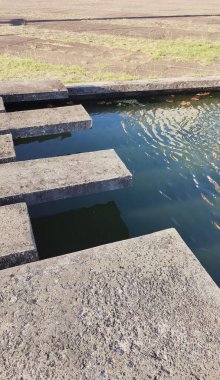 Su aynası ve beton yol mavi gökyüzünü yansıtıyor.