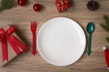 Tabak, çatal ve kaşıkla tahta masa arkaplanlı mutlu Noeller. Xmas, parti ve mutlu yıllar konsepti.