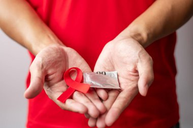 Kırmızı kurdele ve prezervatifle Aralık Dünya Yardım Günü, kazanılmış bağışıklık yetmezliği sendromu, önleme, güvenlik cinsel ve sağlık konsepti