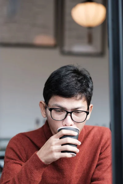 Man in sweater drinking Hot coffee in restaurant