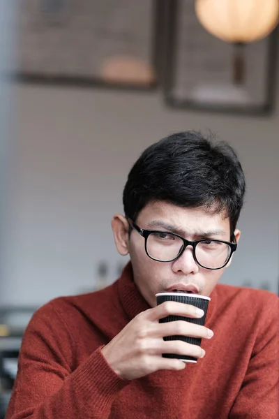 Man in sweater drinking Hot coffee in restaurant
