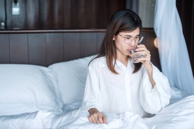 Elinde su bardağı olan mutlu bir kadın, evinde saf su içen bir kadın. Sağlıklı, ferahlatıcı, yaşam tarzı konsepti