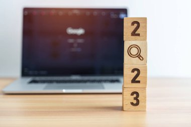 2023 blok, dizüstü bilgisayar arka planında büyüteç simgesi var. İşe alma, adam alma, iş, işsiz SEO, Arama Motoru İyimserleştirme ve Yeni Yıl kavramları