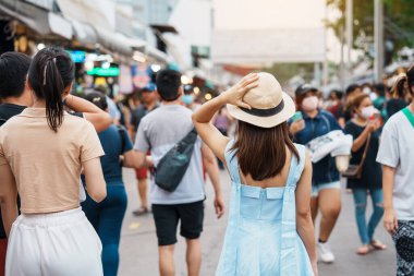 Şapkalı bir kadın, Asyalı bir gezgin Chatuchak Haftasonu Pazarı 'nda duruyor, tarihi bir yer ve Tayland Bangkok' taki turistik etkinlikleriyle tanınıyor. Güneydoğu Asya konseptinde seyahat