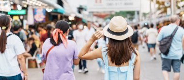 Şapkalı bir kadın, Asyalı bir gezgin Chatuchak Haftasonu Pazarı 'nda duruyor, tarihi bir yer ve Tayland Bangkok' taki turistik etkinlikleriyle tanınıyor. Güneydoğu Asya konseptinde seyahat