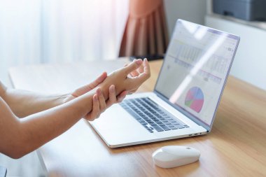 İş yerinde uzun süre fare kullanırken bileği ağrıyan bir kadın. De Quervain 's tenosynovitis, ergonomic, Carpal Tunnel Sendromu veya Office sendromu