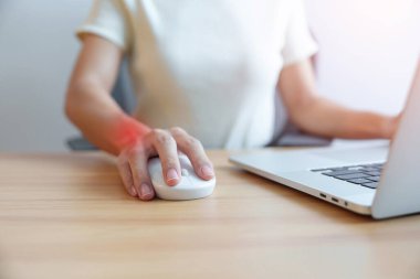 İş yerinde uzun süre fare kullanırken bileği ağrıyan bir kadın. De Quervain 's tenosynovitis, ergonomic, Carpal Tunnel Sendromu veya Office sendromu