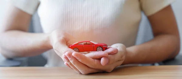 Hand holding Car toy. Vehicle insurance, warranty, Automobile rental, Transportation, Maintenance and repair concept.