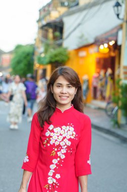 Mutlu kadın Ao Dai Vietnamlı elbisesi giyiyor, Asyalı gezgin Hoi 'yi geziyor Orta Vietnam' da antik bir kasaba. Tarihi bir yer ve turistik yerlerin gözdesi. Vietnam ve Güneydoğu seyahat kavramı