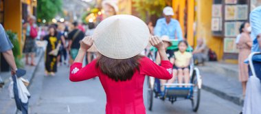 Mutlu kadın Ao Dai Vietnamlı elbisesi giyiyor, Asyalı gezgin Hoi 'yi geziyor Orta Vietnam' da antik bir kasaba. Tarihi bir yer ve turistik yerlerin gözdesi. Vietnam ve Güneydoğu seyahat kavramı