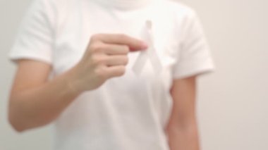 Kasım ayı akciğer kanseri farkındalığı ayı, demokrasi ve uluslararası barış günü için beyaz kurdele tutan kadın. Sağlık hizmetleri kavramı