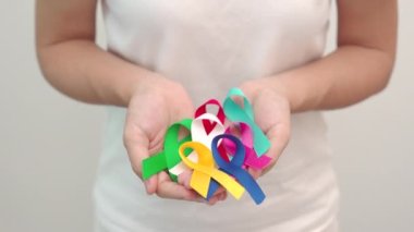 Dünya Kanser Günü, 4 Şubat. Yaşayanları ve hastalıkları desteklemek için renkli kurdeleler. Sağlık, Dövüş, Sağlık ve Ulusal Kanser Günü, Otizm Farkındalık Günü konsepti