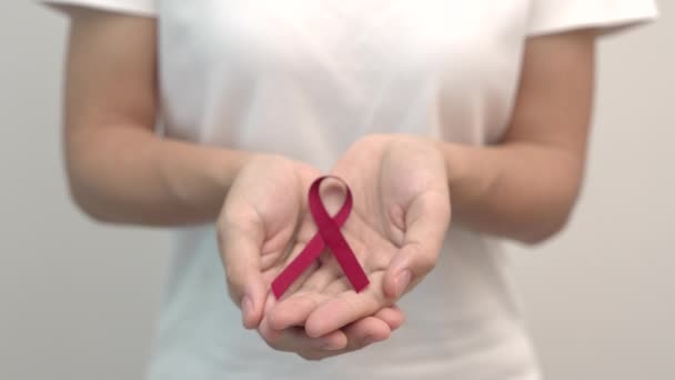 12月の世界エイズデー 多発性骨髄腫がん啓発月間 ナショナルレッドリボンウィークのために手を握っています 医療と世界のがんの日のコンセプト — ストック動画