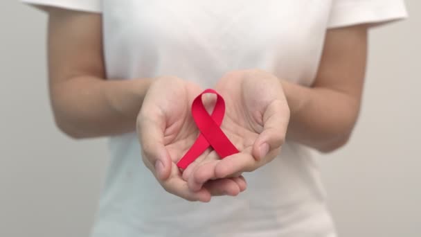 12月の世界エイズデーのためのレッドリボンを手に持って 免疫不全症候群 多発性骨髄腫のがん啓発月とナショナルレッドリボンの週を取得しました 医療と世界のがんの日 — ストック動画