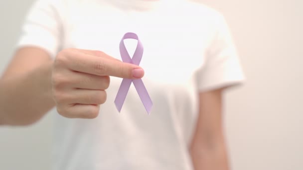 2月4日の世界がんデー 女性の手は 生活や病気をサポートするためのラベンダー紫色のリボンを保持 医療の概念 — ストック動画