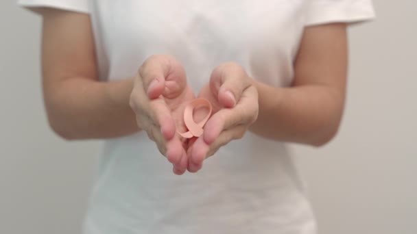 Vrouw Hand Houden Peach Ribbon Voor September Uterine Cancer Awareness — Stockvideo