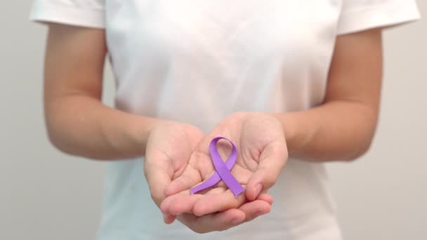精巣癌 世界アルツハイマー てんかん ループス サルコイドーシス 線維筋痛症 家庭内暴力意識月のための紫色のリボンを保持手 世界がんの日のコンセプト — ストック動画
