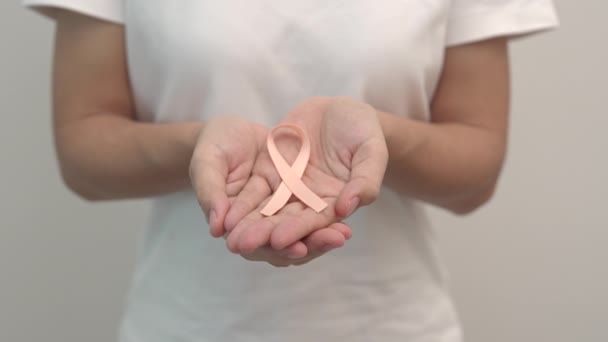 Wanita Tangan Memegang Peach Ribbon Untuk Bulan September Uterine Cancer — Stok Video