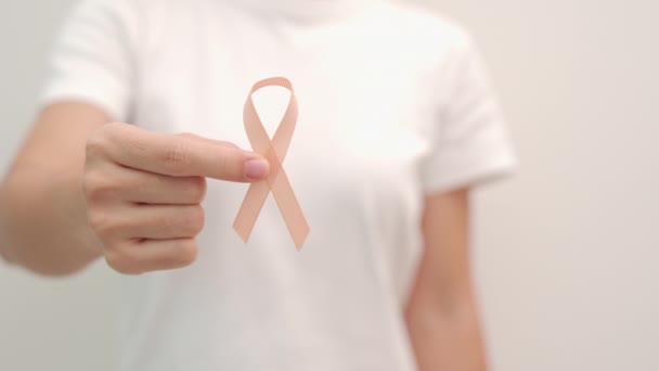 Vrouw Hand Houden Peach Ribbon Voor September Uterine Cancer Awareness — Stockvideo