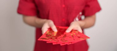 Woman holding Chinese red envelope, money gift for happy Lunar New Year holiday