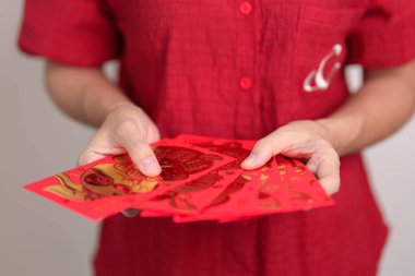 woman holding Chinese red envelope with golden rabbit and blessing word, money gift for happy Lunar New Year holiday. Chinese sentence means happiness, healthy, Lucky and Wealthy