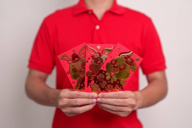 man holding Chinese red envelope with golden rabbit and blessing word, money gift for happy Lunar New Year holiday. Chinese sentence means happiness, healthy, Lucky and Wealthy