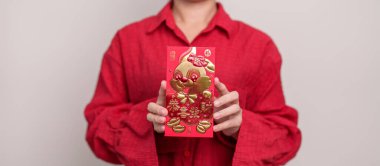 woman holding Chinese red envelope with golden rabbit and blessing word, money gift for happy Lunar New Year holiday. Chinese sentence means happiness, healthy, Lucky and Wealthy