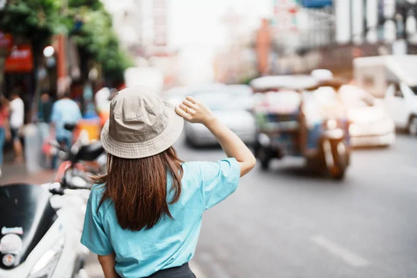 Young Woman with hat traveling in Bangkok, Asian traveler visiting at Yaowarat road or Chinatown of Bangkok, landmark and popular for tourist attractions in Thailand. Southeast Asia Travel concept