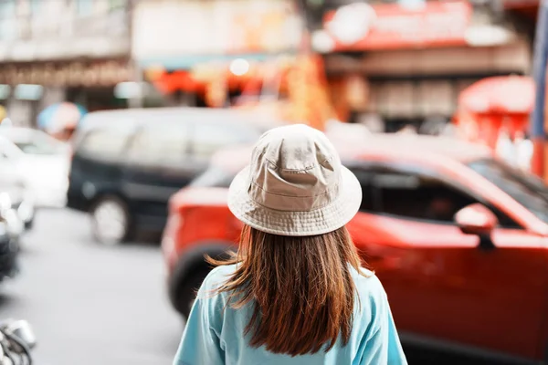 Young Woman with hat traveling in Bangkok, Asian traveler visiting at Yaowarat road or Chinatown of Bangkok, landmark and popular for tourist attractions in Thailand. Southeast Asia Travel concept