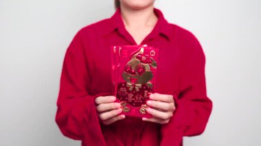 Woman holding Chinese red envelope, money gift for happy Lunar New Year holiday