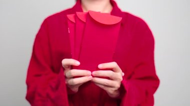 Woman holding Chinese red envelope, money gift for happy Lunar New Year holiday