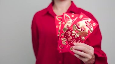 Woman holding Chinese red envelope, money gift for happy Lunar New Year holiday