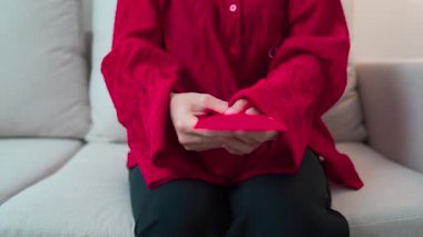Woman holding Chinese red envelope, money gift for happy Lunar New Year holiday