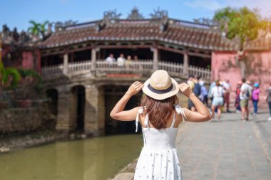 Japon köprüsünü gezen kadın gezginler ya da Hoi 'deki Cau tapınağı. Eski bir kasaba, Vietnam. Tarihi bir yer ve turistik yerlerin gözdesi. Vietnam ve Güneydoğu Asya seyahat kavramı