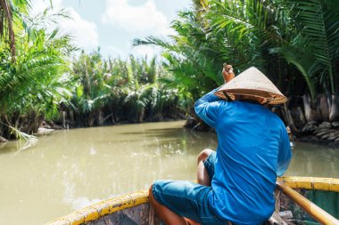 Hindistan cevizi nehir ormanı boyunca kürek çeken bir adam. Cam Thanh köyünde eşsiz bir Vietnamlı. Hoi An 'da turistler için önemli ve popüler bir yer. Vietnam ve Güneydoğu Asya seyahat kavramları