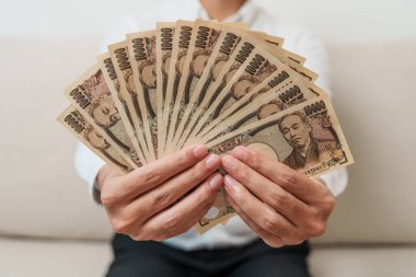 man hand holding Japanese Yen banknote stack. Thousand Yen money. Japan cash, Tax, Recession Economy, Inflation, Investment, finance and shopping payment concepts